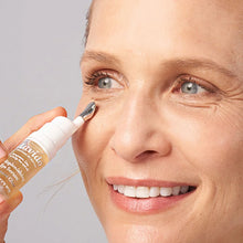 Load image into Gallery viewer, Smiling woman rolling Lavido Instant Glow Restorative Eye Serum under her eye