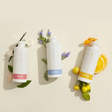Load image into Gallery viewer, Three Lavido body wash bottles laid flat with flowers, lavender and citrus